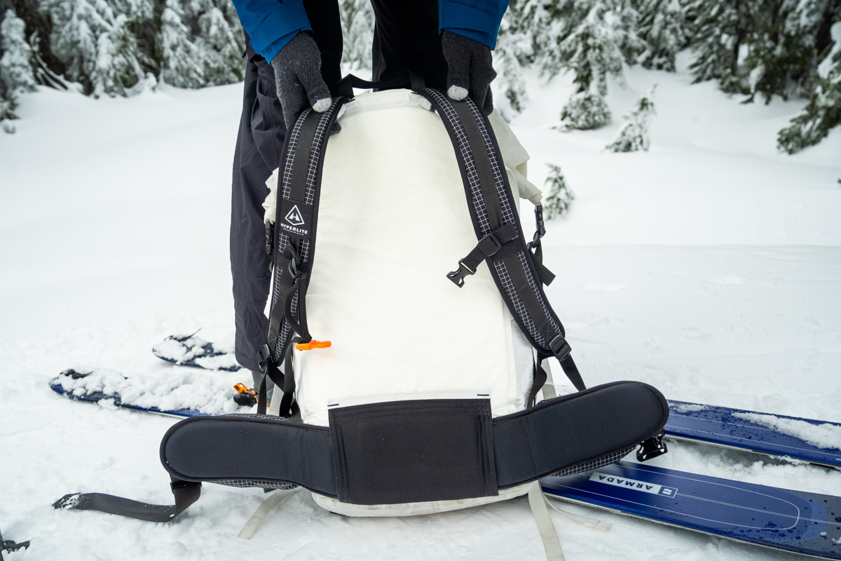 A close up of the backpanel and shouder straps and hipbelt on a white ski backpack